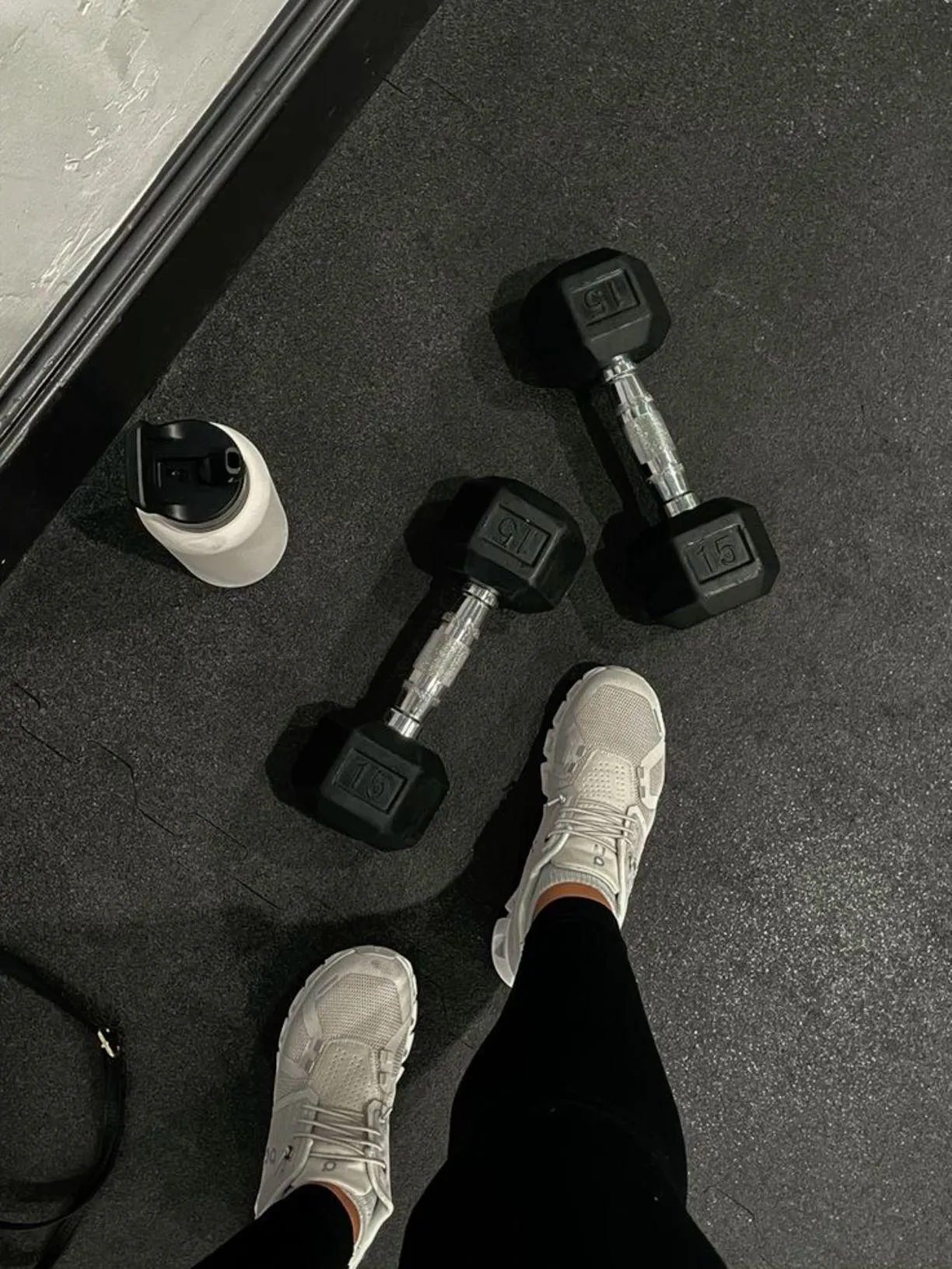 Top View of Dumbbells Water Bottle and Shoes on Gym Floor