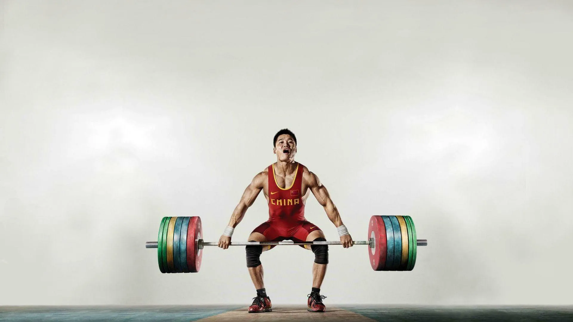 Weightlifter Performing a Lift With Colorful Weights Outside