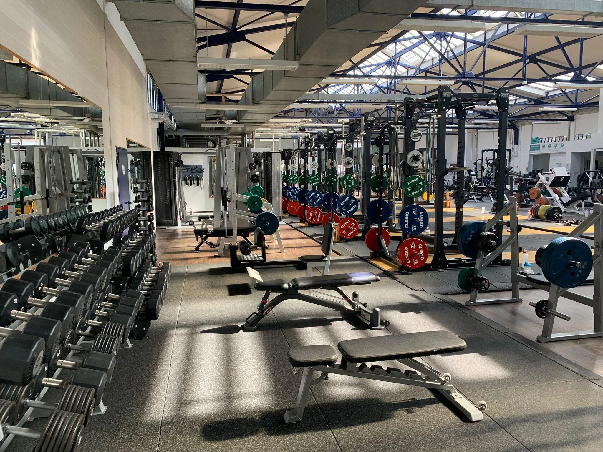 Wide Gym Area With Benches and Weightlifting Equipment