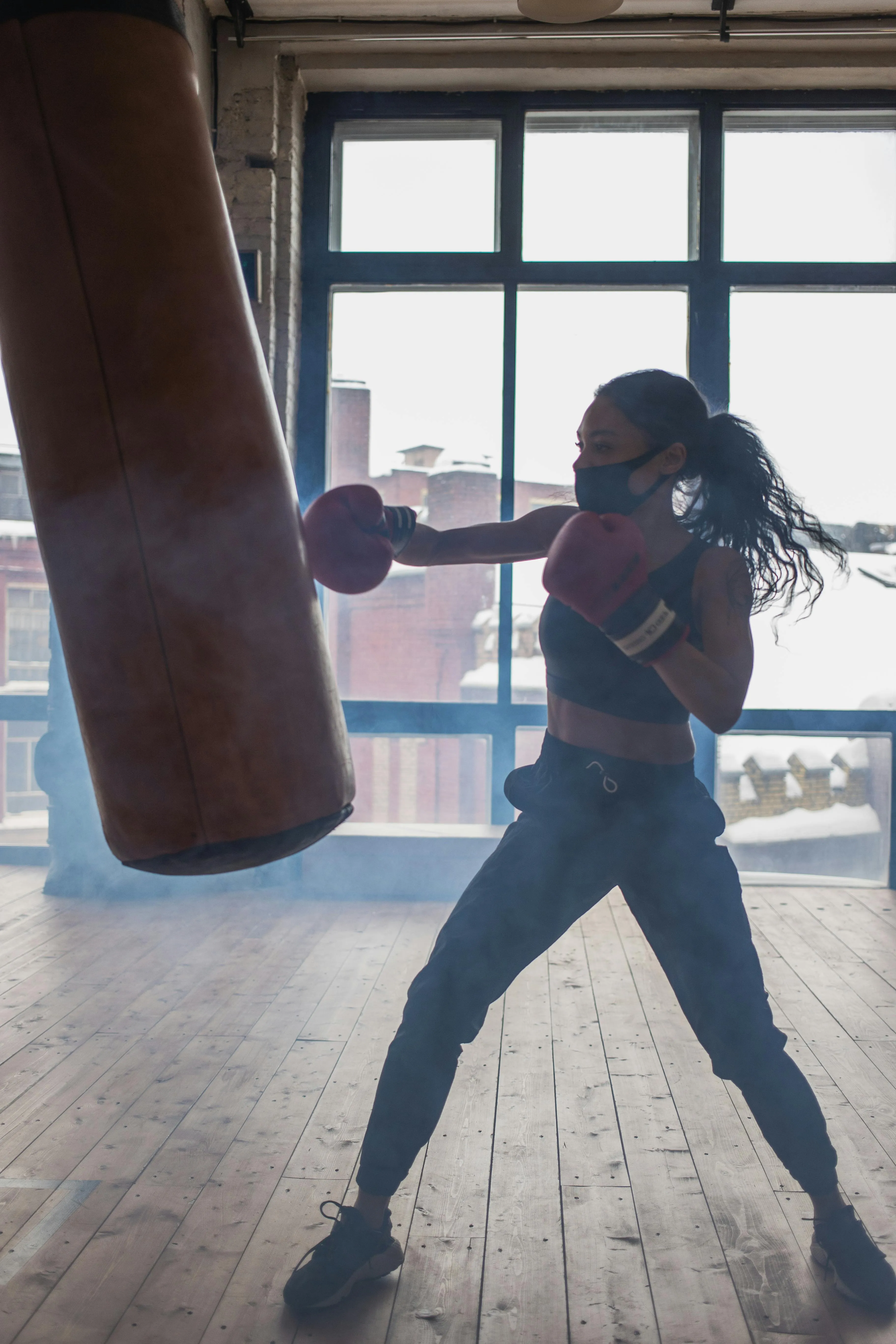 Woman Boxing With a Punching Bag Inside a Training Area