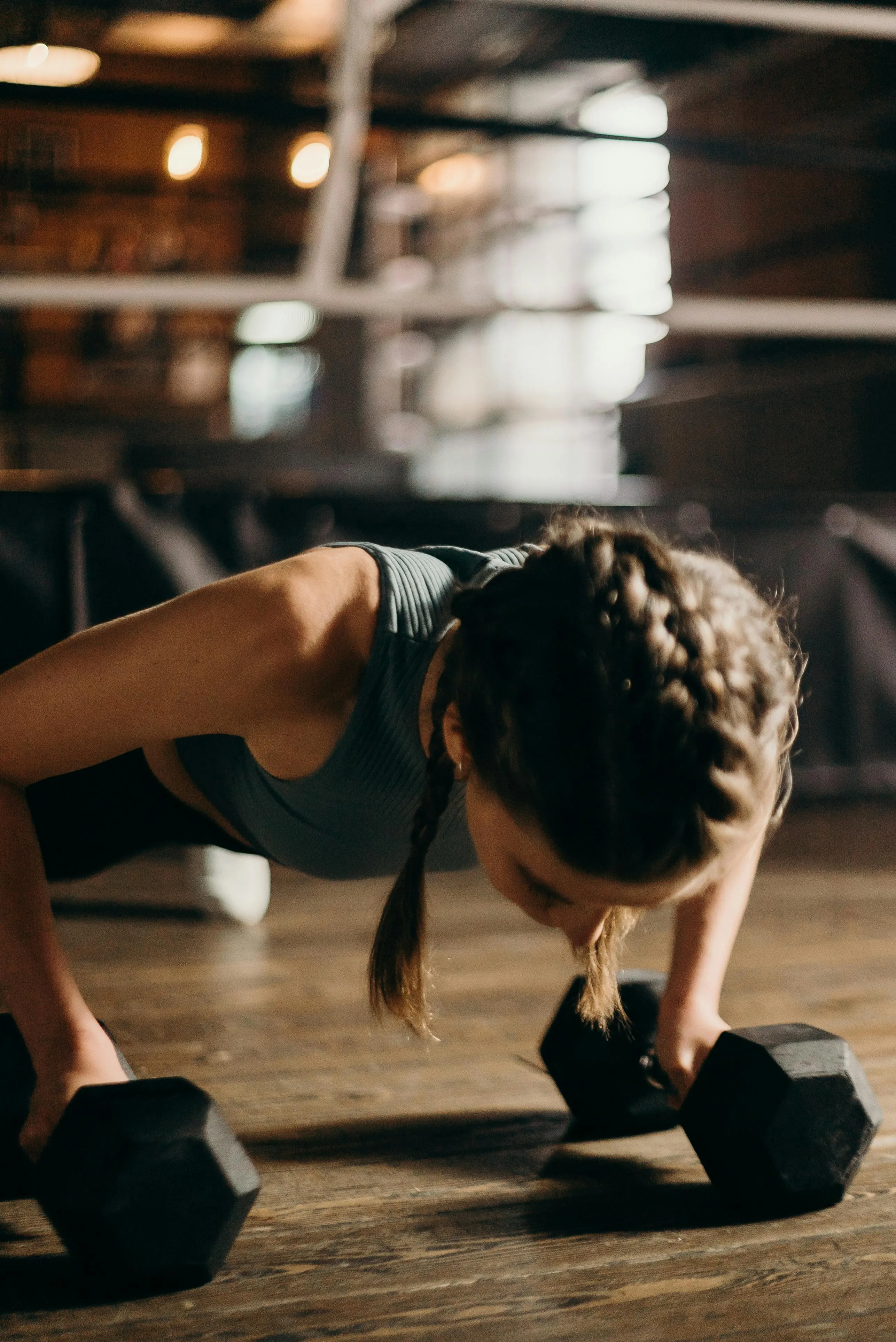 Woman Holding Dumbbells in a Plank For Strength Training