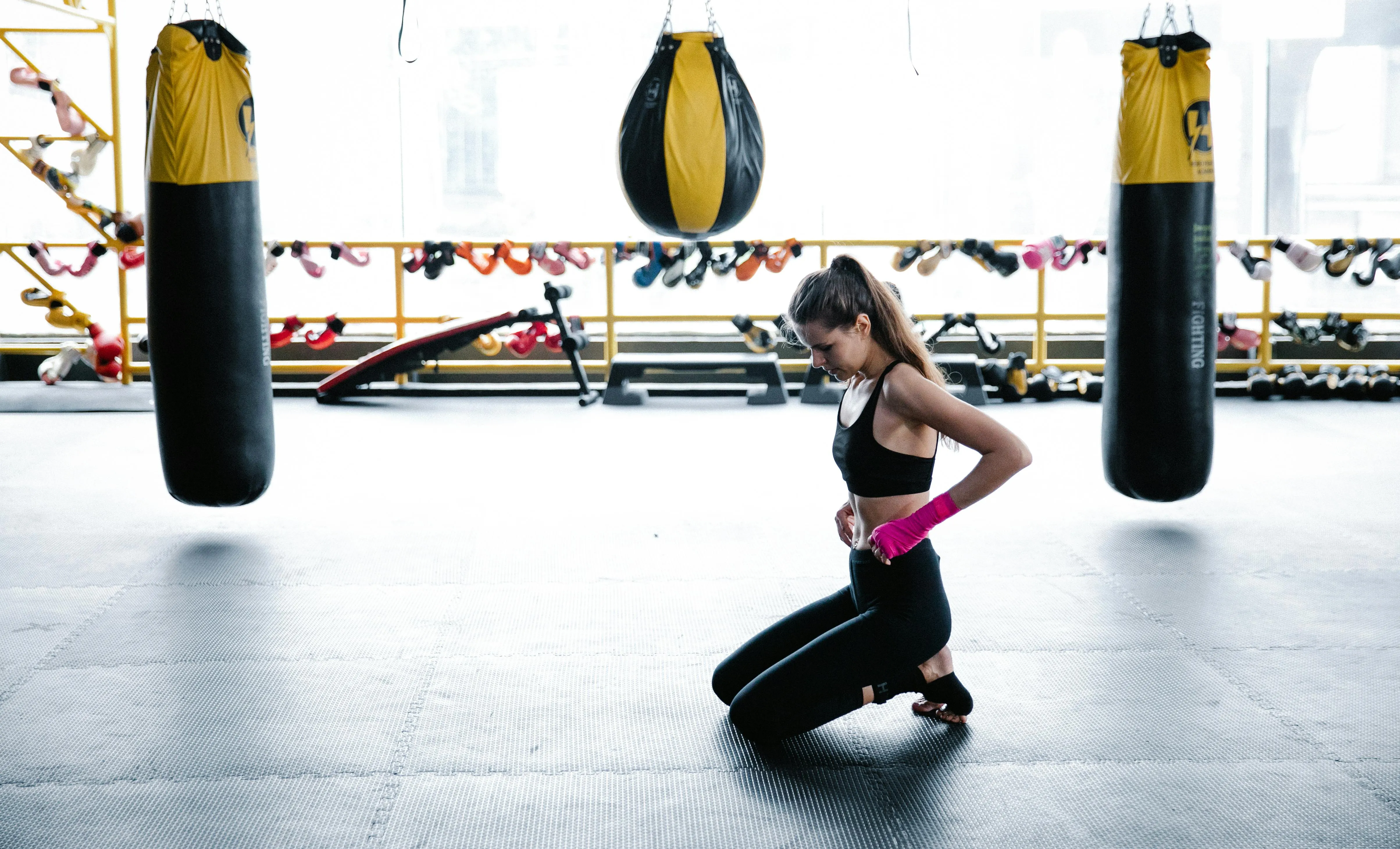 Woman Preparing For Boxing Workout in Gym With Punching Bags