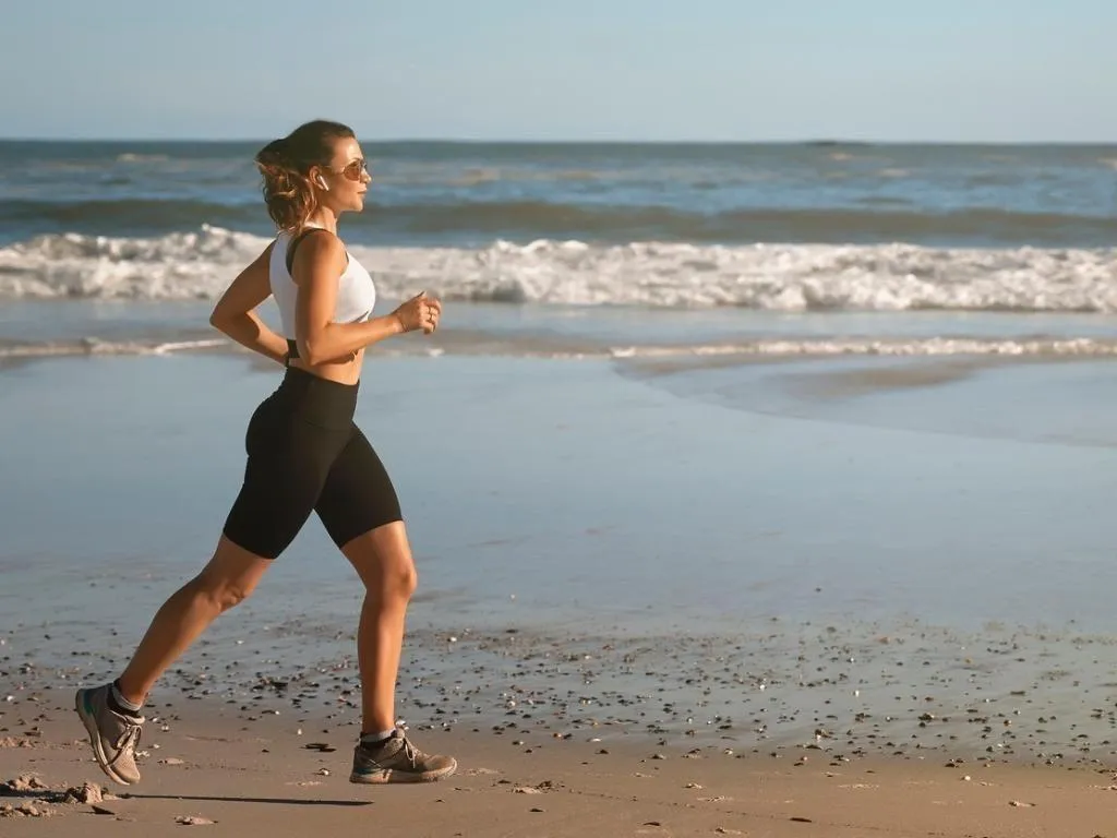 Woman Running on the Beachside in Morning Fitness Routine