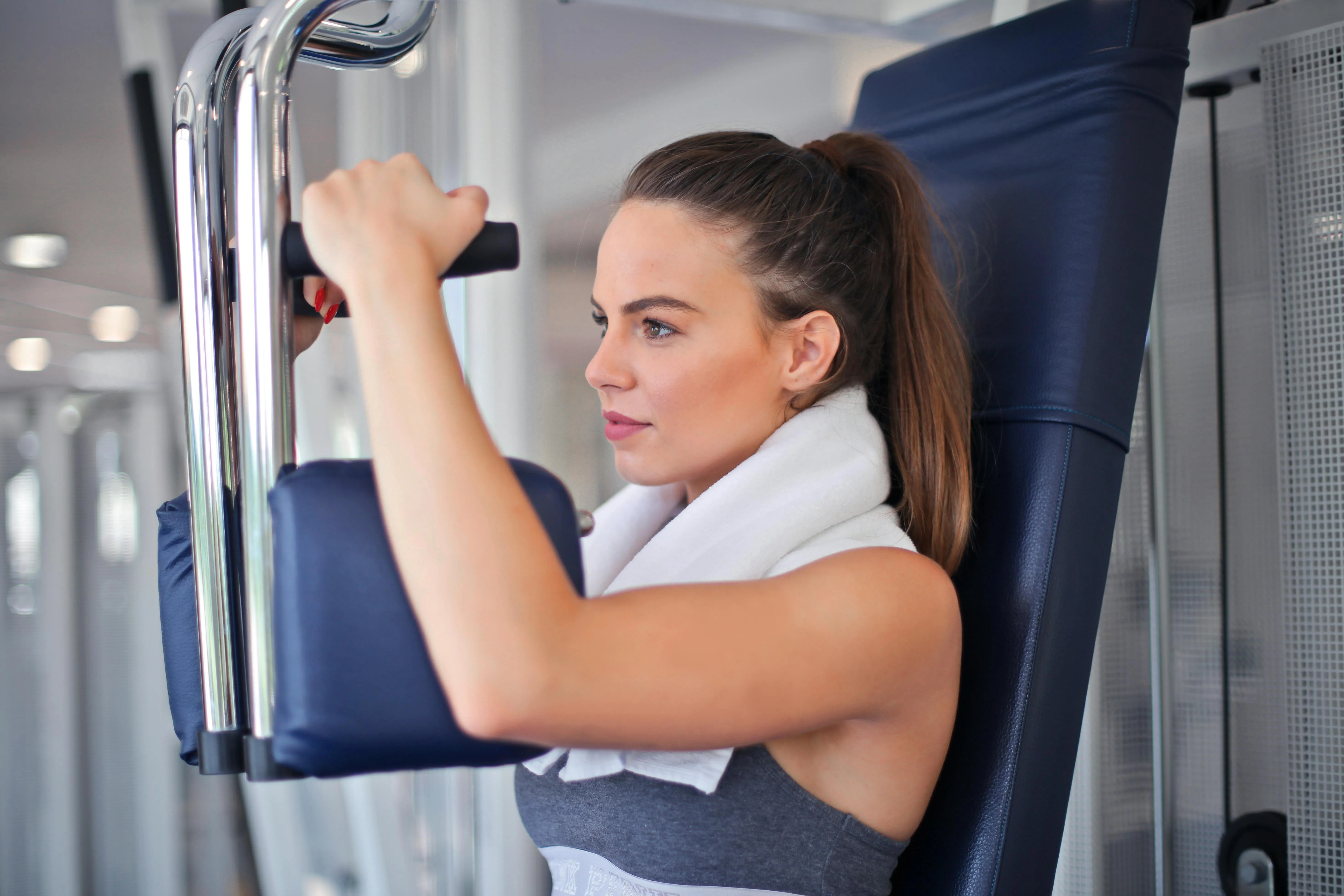 Woman Using a Machine For Shoulder Workout in a Gym Session
