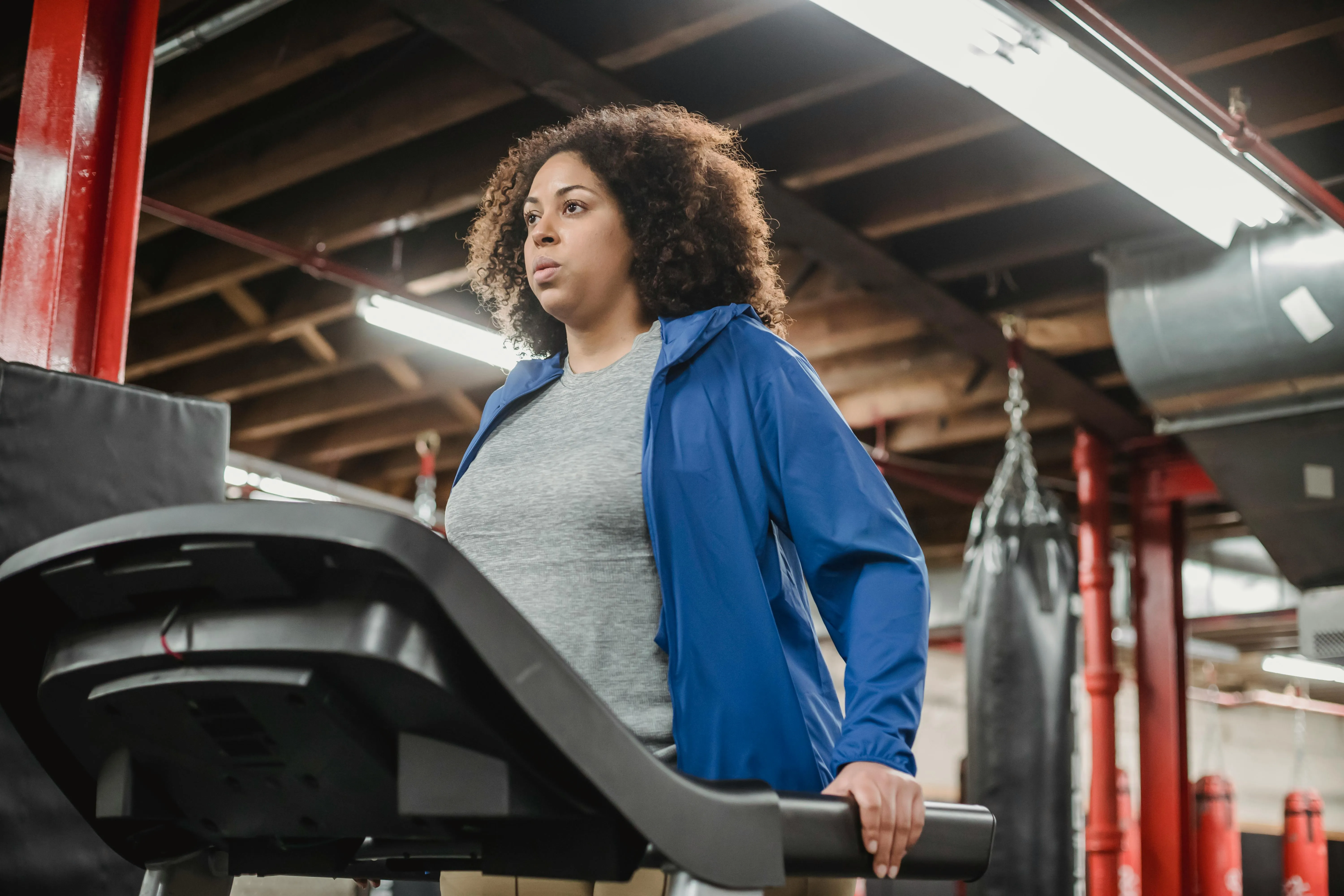 Woman Walking on a Treadmill Wearing a Blue Jacket Wallpaper