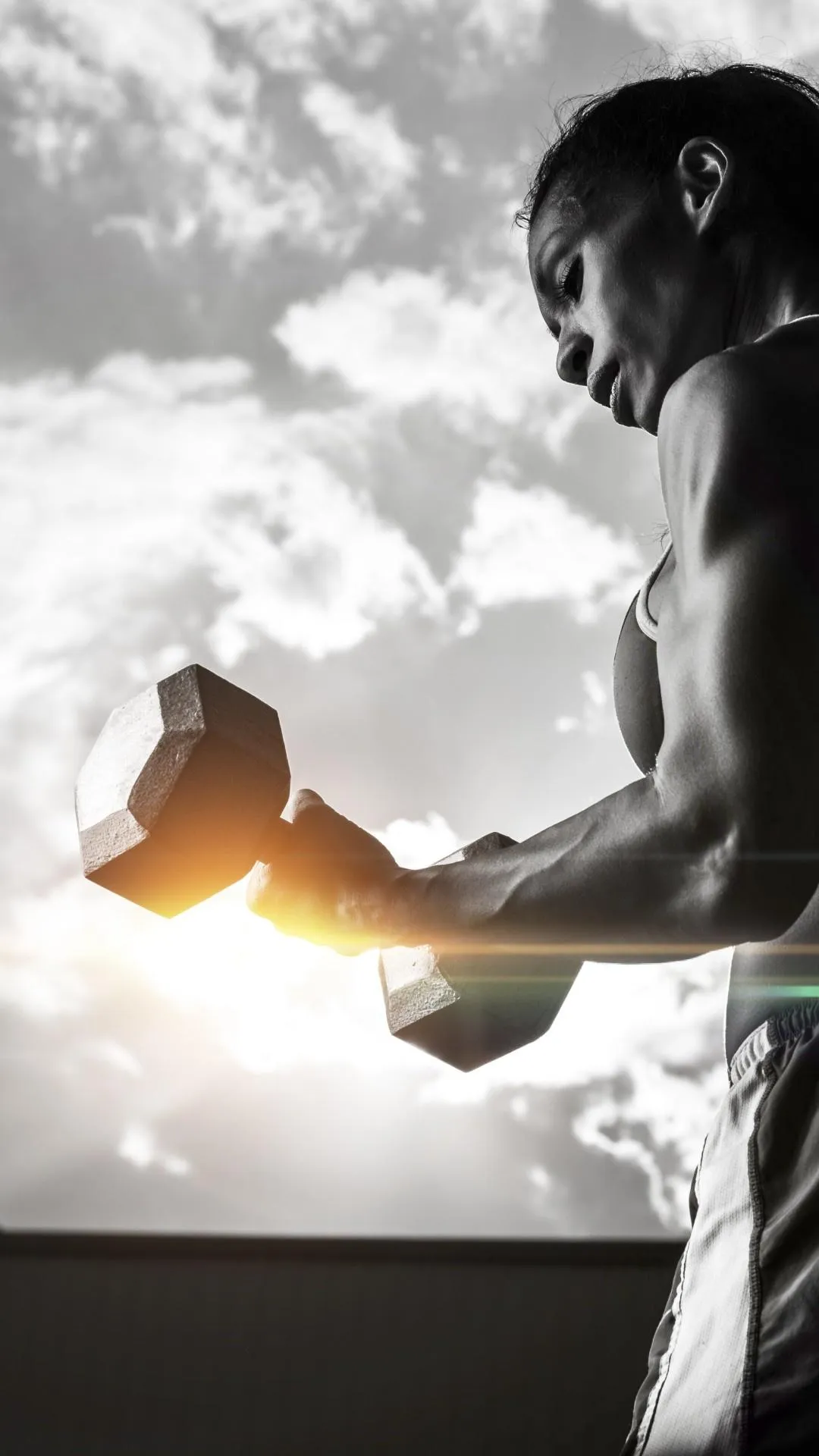 Women Lifting Dumbbell With the Sun Shining in the Outdoor