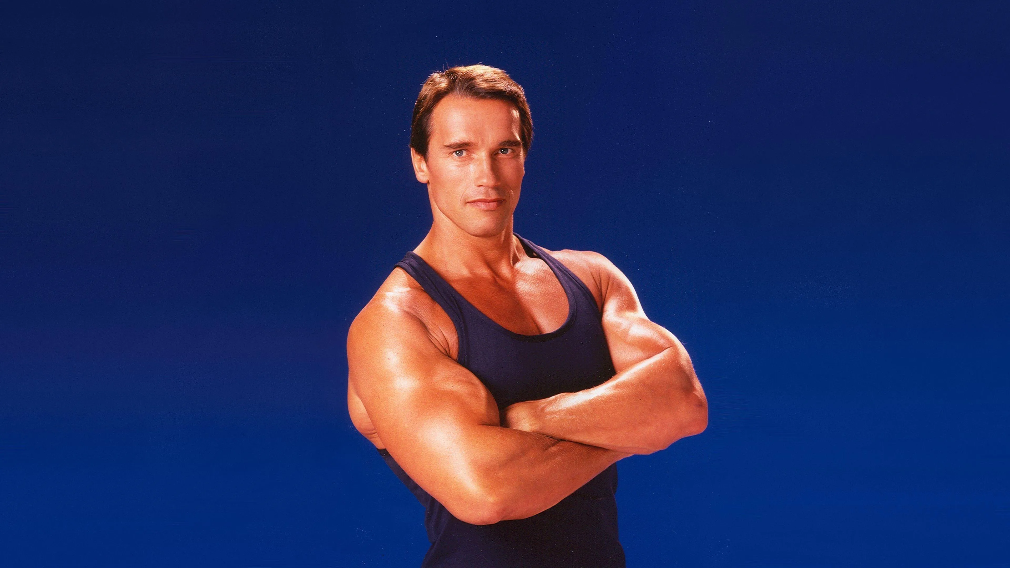 Young Arnold With Folded Arms and Smiling Free Wallpaper