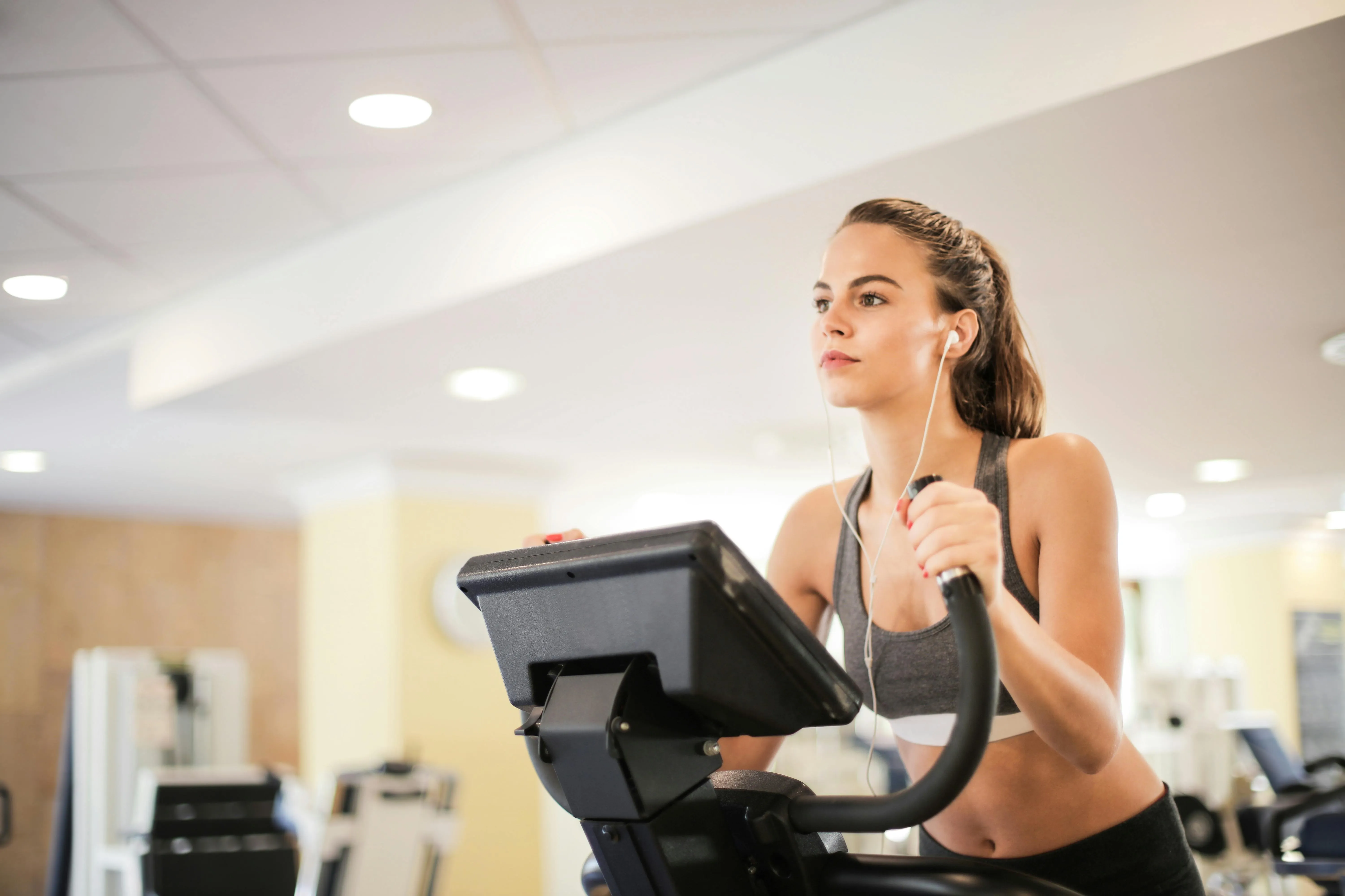 Young Woman Focused on Cardio Training on a Treadmill