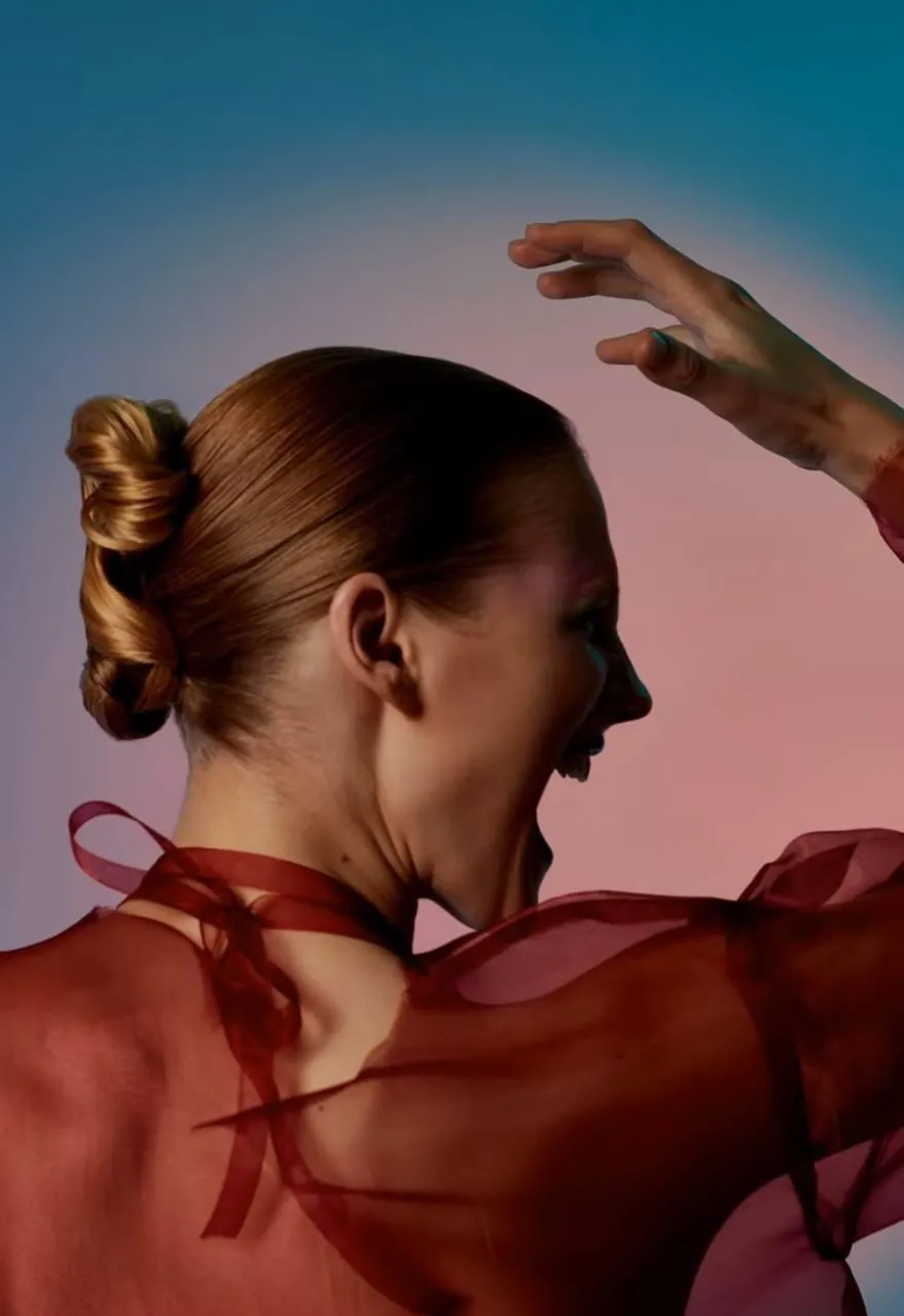 Artistic back view of a woman shouting in a red sheer fabric