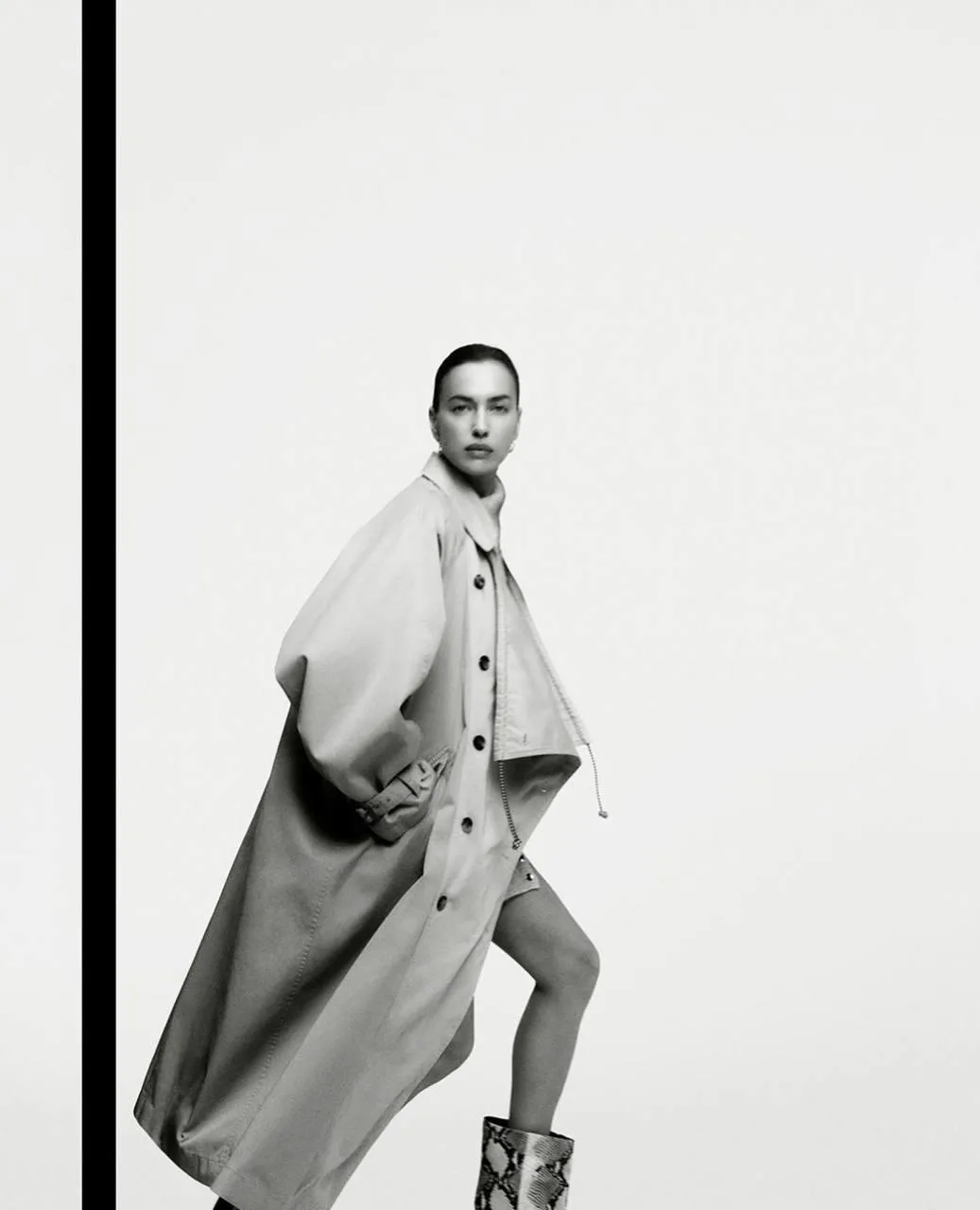 Artistic black and white image of a woman with a long coat