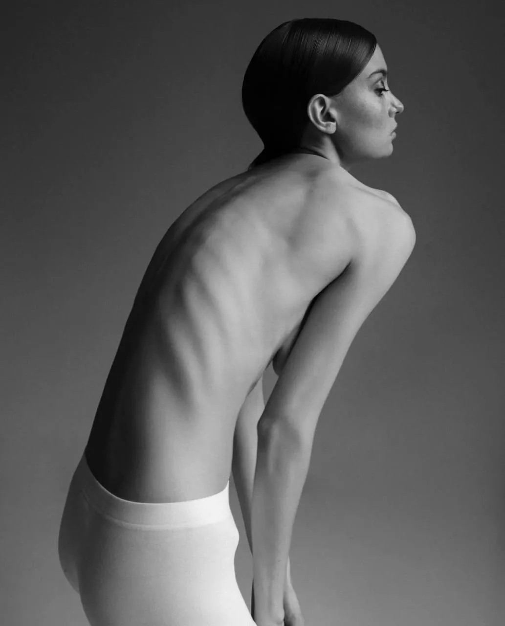 Artistic black and white photo of a slender woman posing