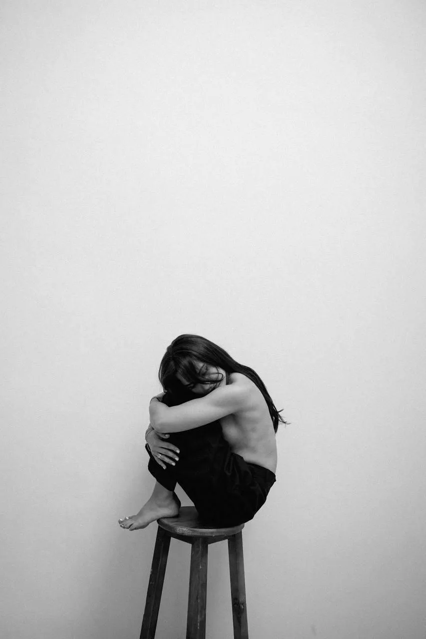 Artistic black and white portrait of a woman on a stool