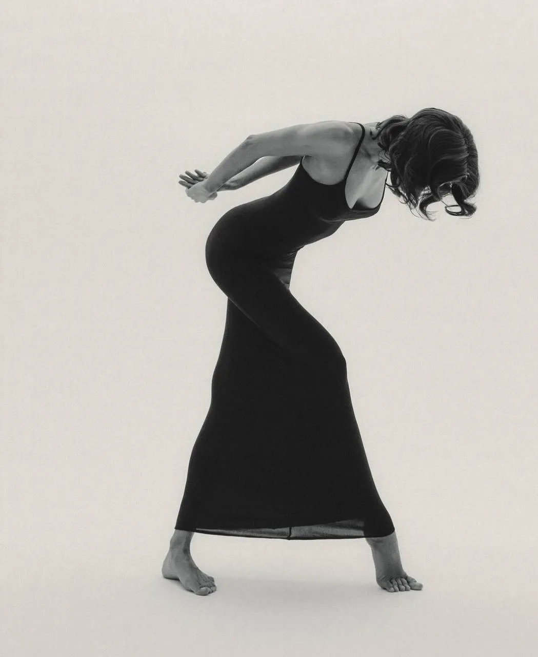 Artistic black and white pose of woman in form fitting dress