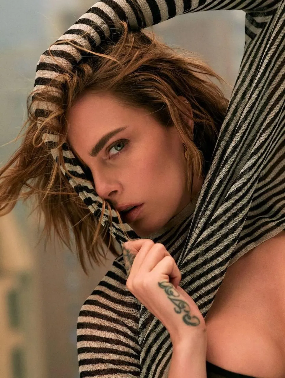 Artistic Portrait of a Woman Hiding in a Striped Fabric