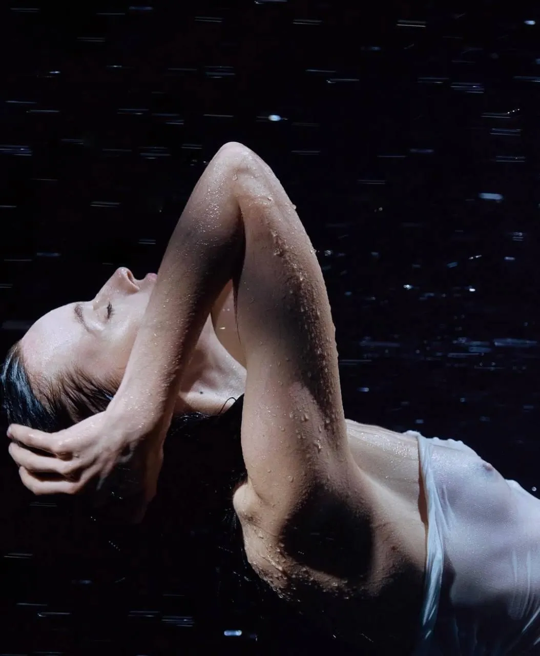 Artistic underwater pose of a model in dramatic lighting