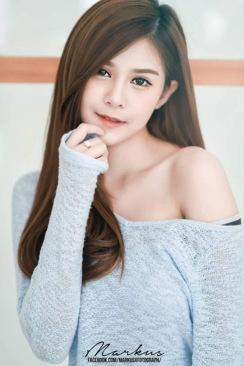 Asian Woman in an Off Shoulder Sweater Posing Thoughtfully