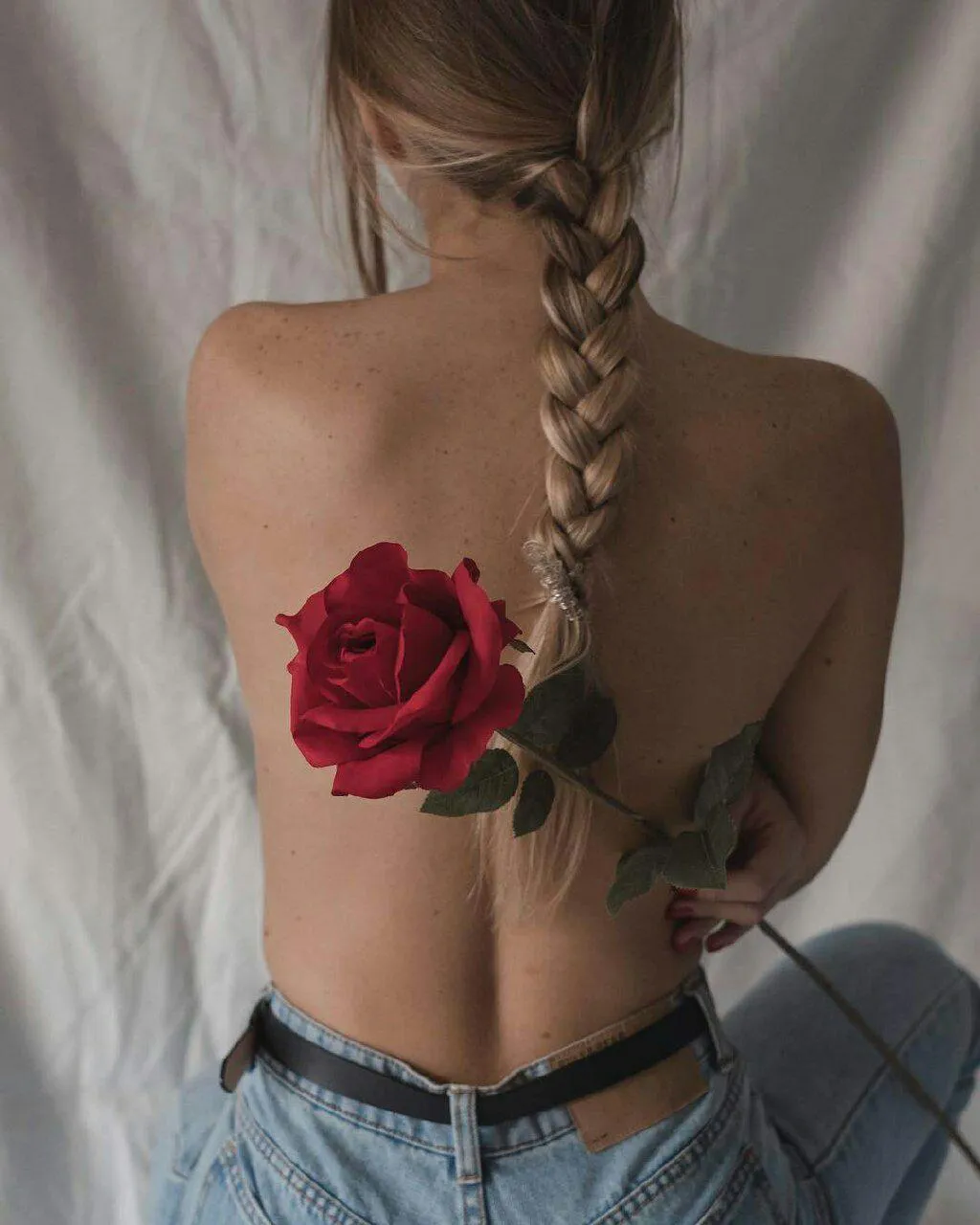 Back View of a Woman with a Braid And a Rose Tucked in Jeans