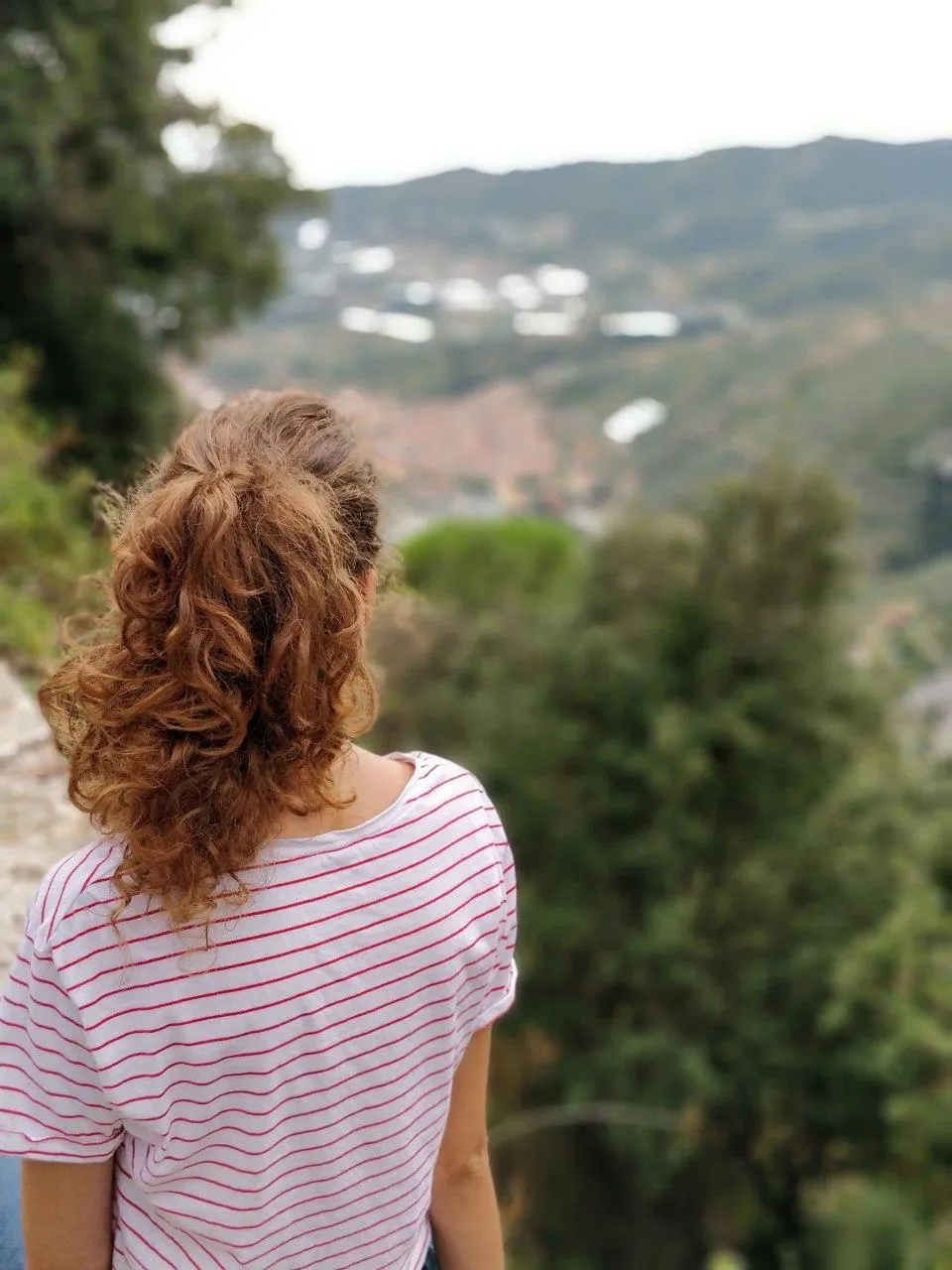 Back View of a Woman with Curly Hair Looking at Landscape