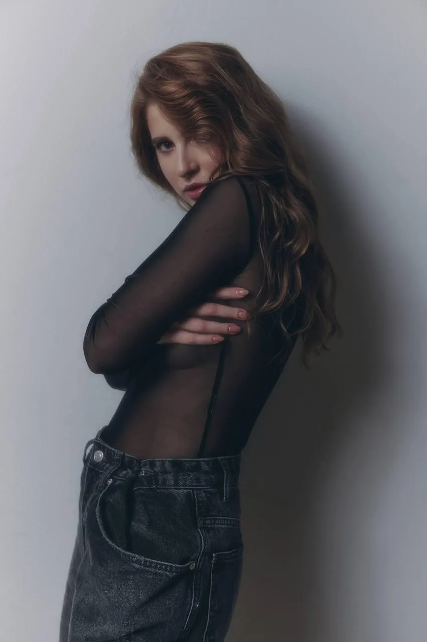 Beautiful woman in a transparent mesh top and looking back