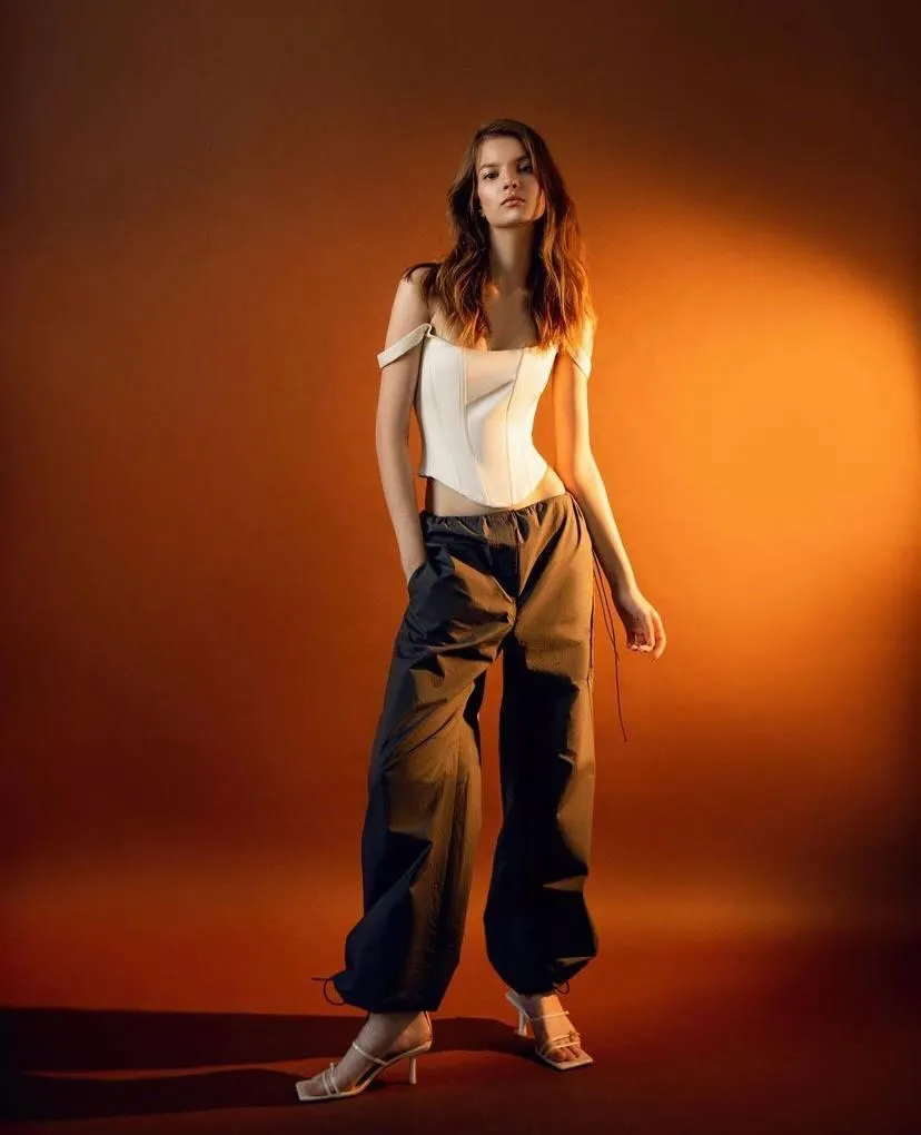 Beautiful woman standing near the orange background image