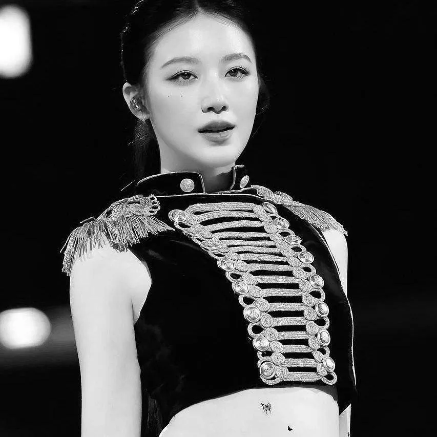 Black and white close up of a woman in a decorated jacket