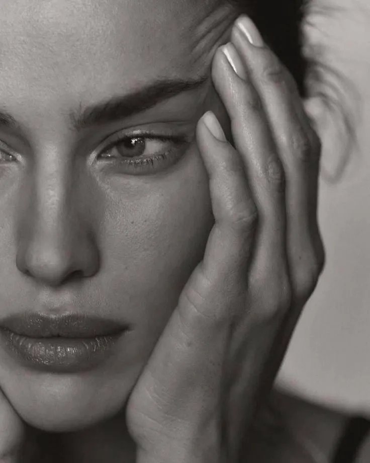 Black and white close up of a woman with hand on her cheek