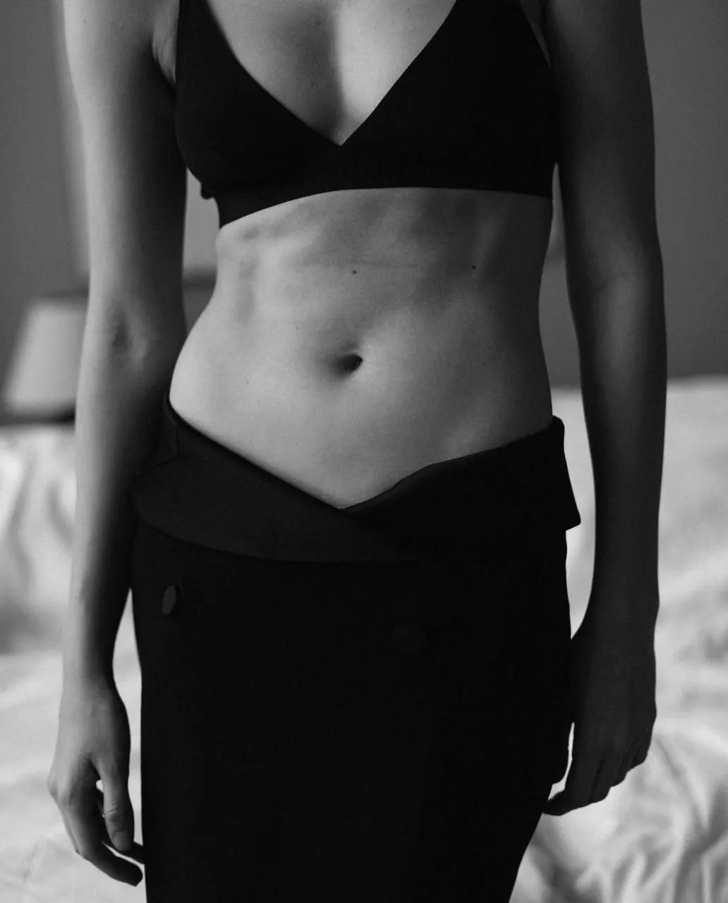 Black and white crop of woman in bikini with muscular torso