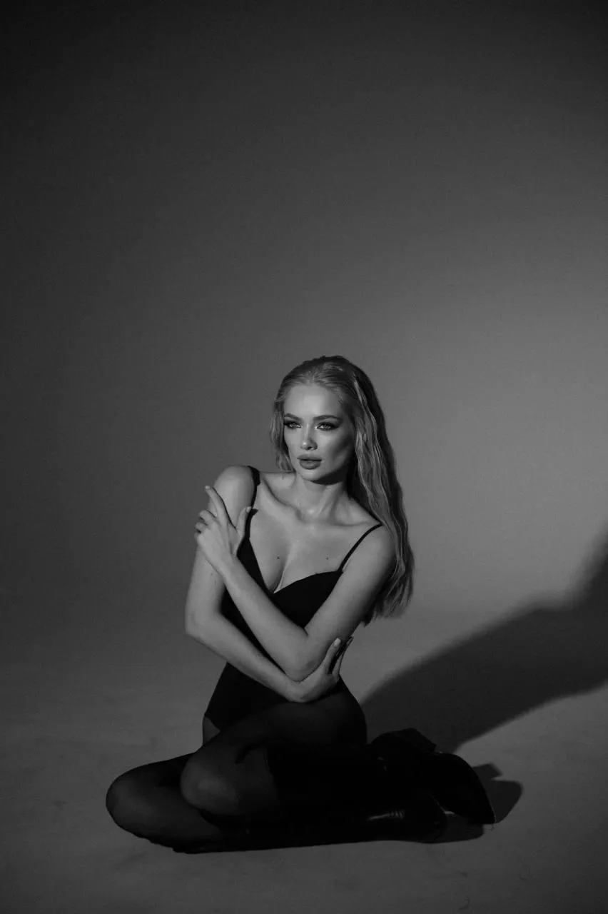 Black and white image of a woman sitting cross legged pose