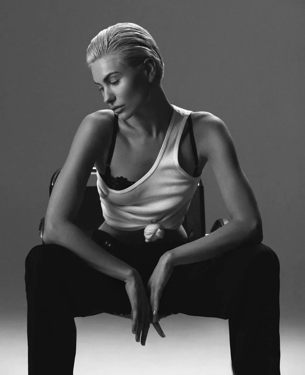 Black and white image of short haired woman sitting casually