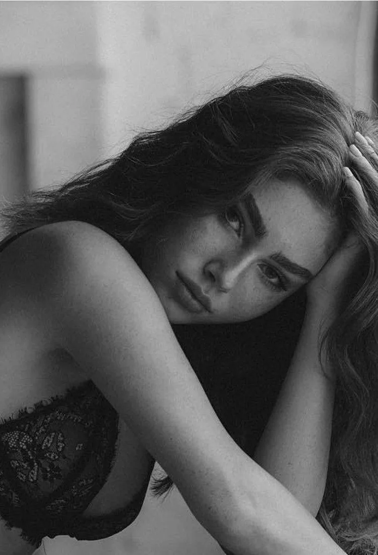 Black and white image of woman in lace with moody expression