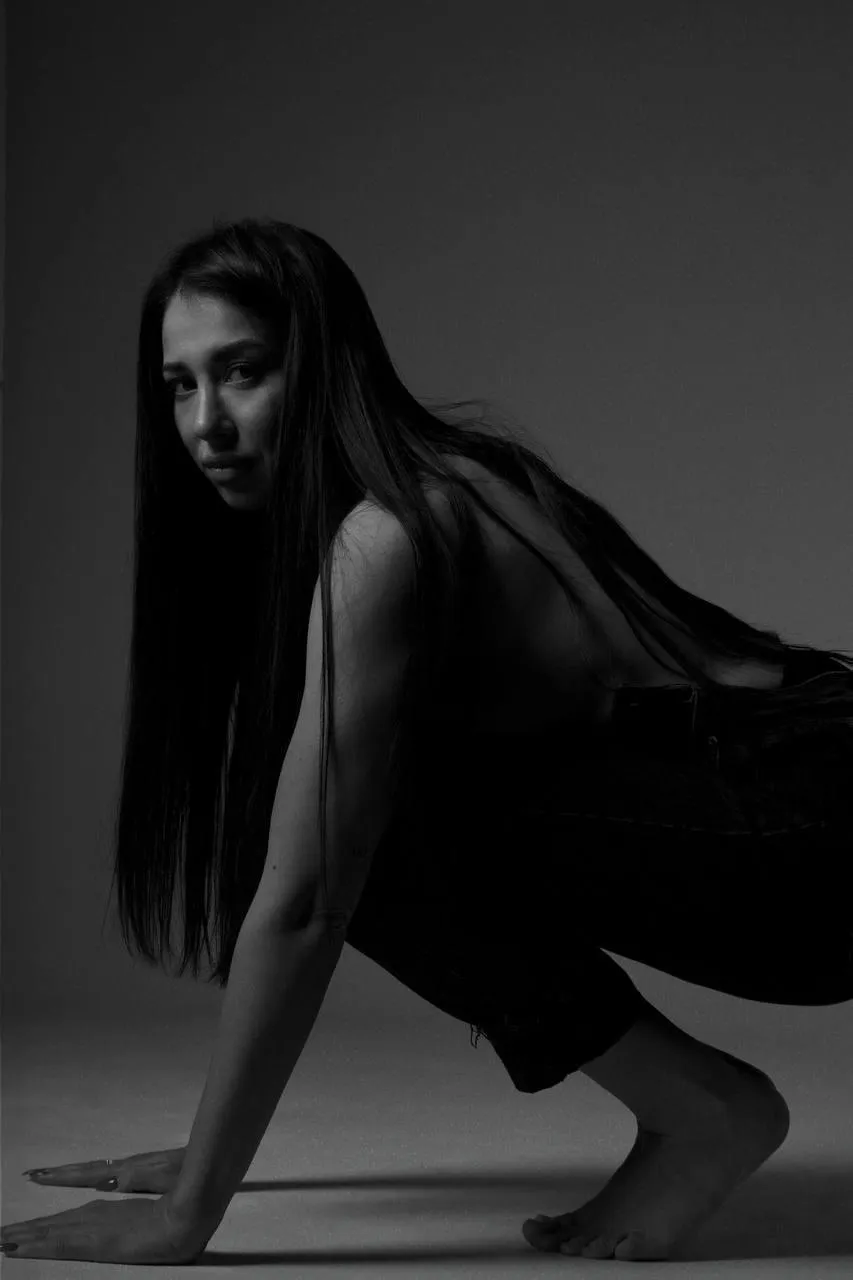 Black and white of a woman squatting on the studio floor