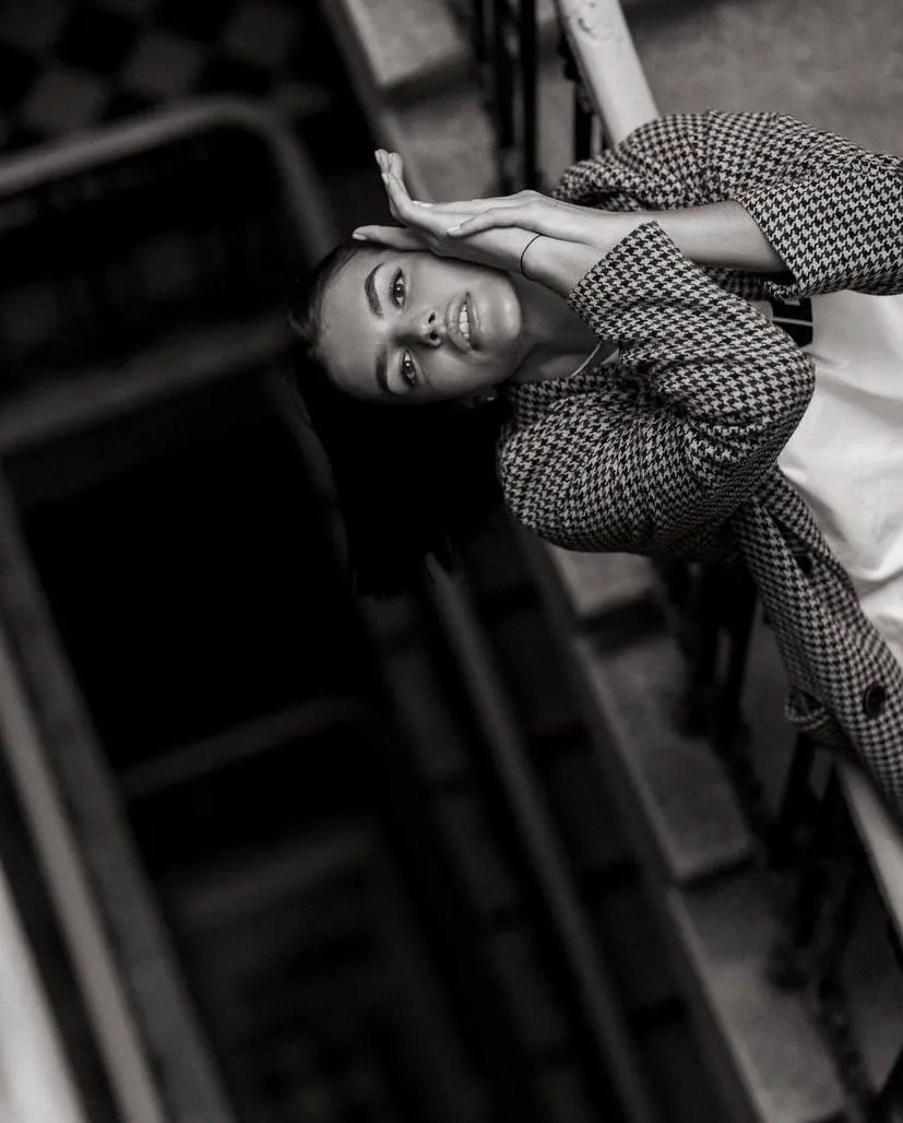 Black and white of woman leaning on an industrial structure