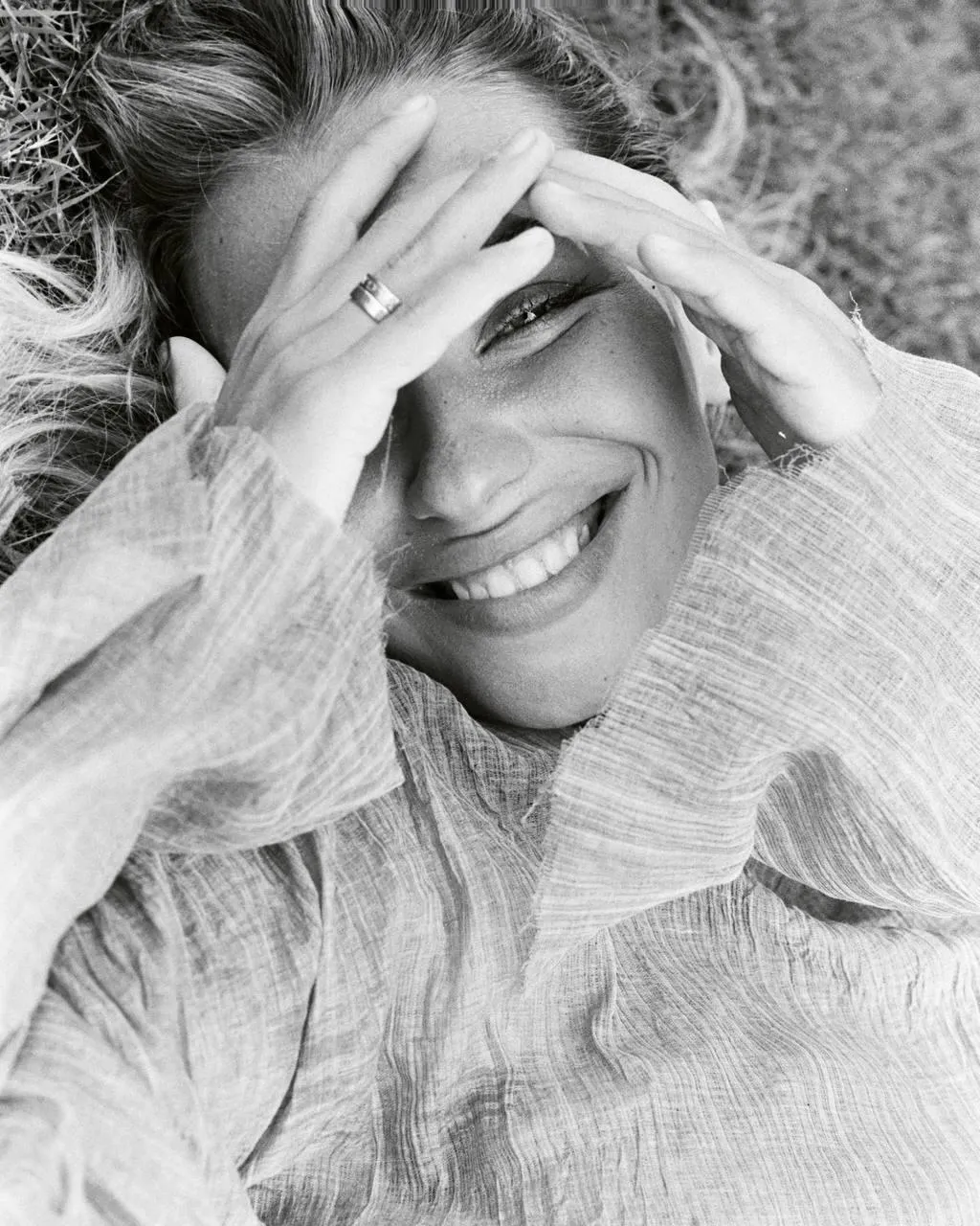 Black And White Photo of a Smiling Woman Covering Her Face