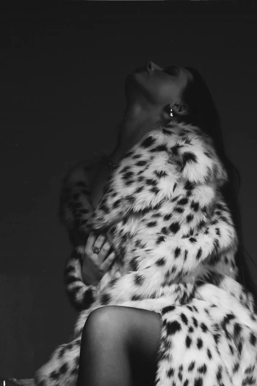 Black and white photo of a woman in a leopard print coat