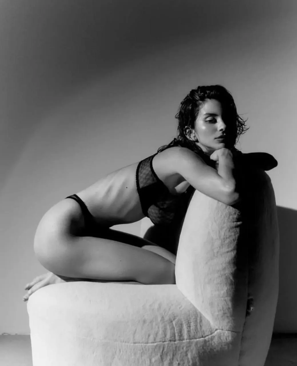 Black and white photo of a woman reclining on a sofa image