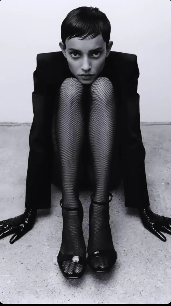 Black and white photo of a woman sitting in formal attire