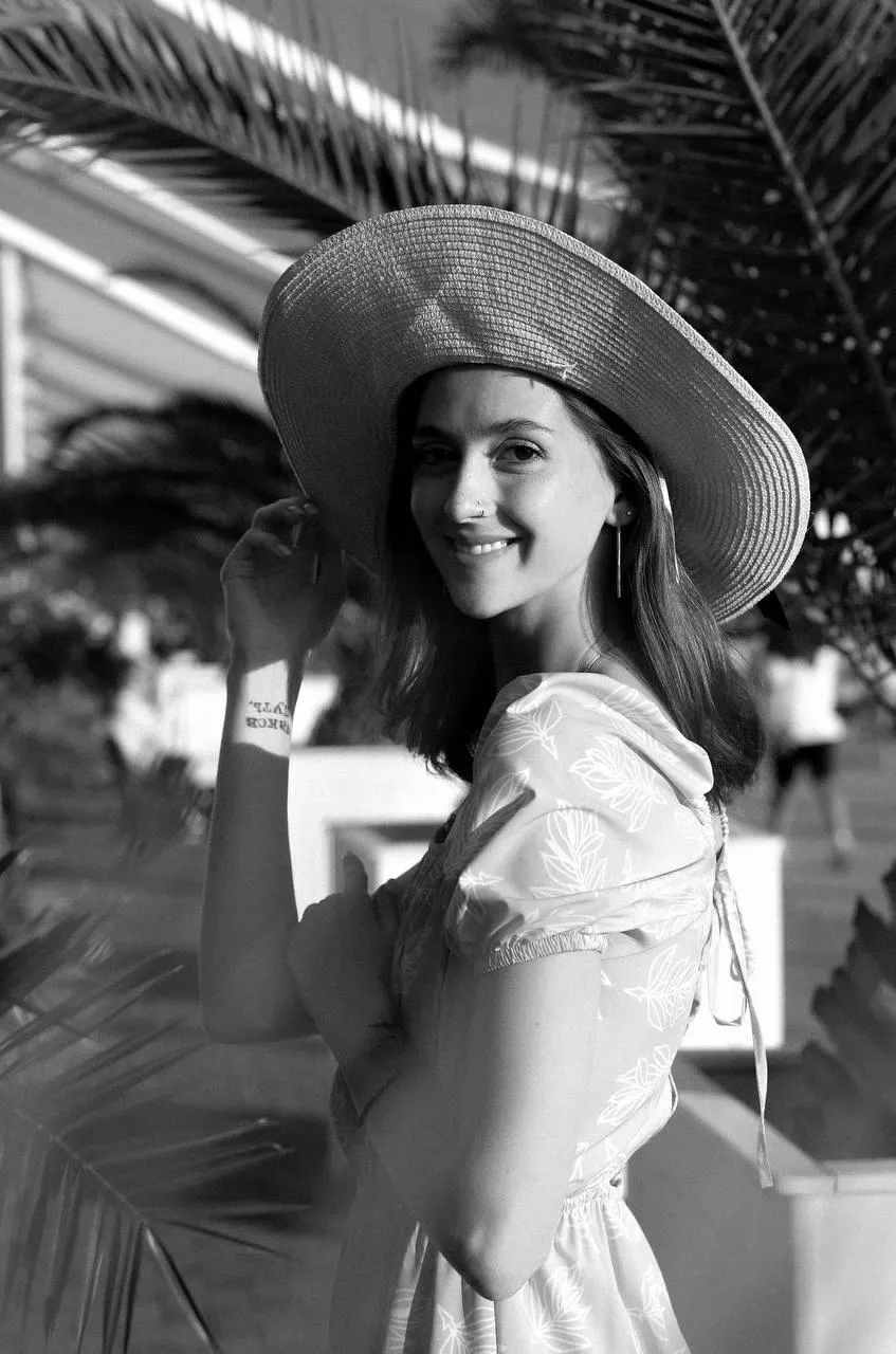 Black And White Photo of a Woman Smiling in a Wide Brim Hat
