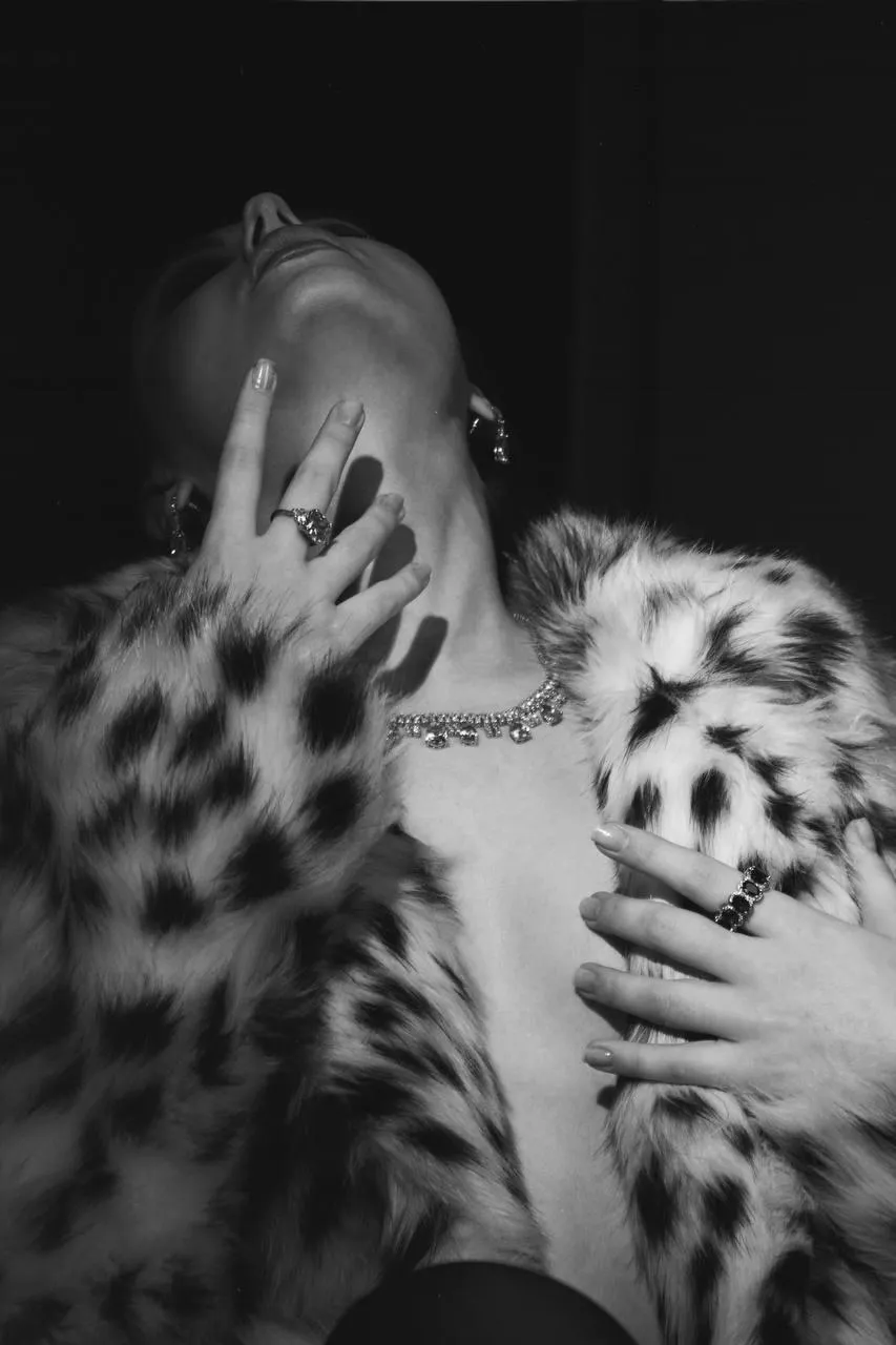 Black and white photo of a woman with her hands over face