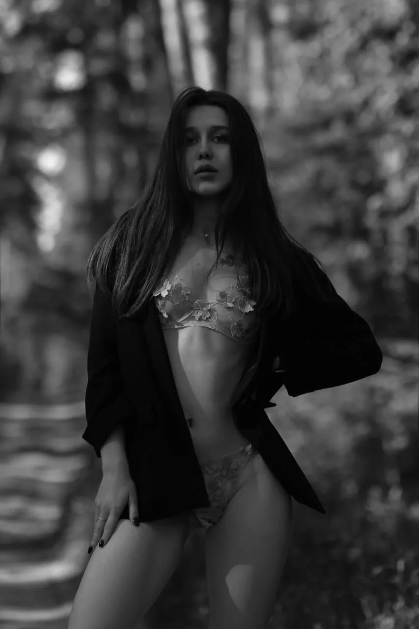 Black and white photo of woman in a blazer standing outdoors