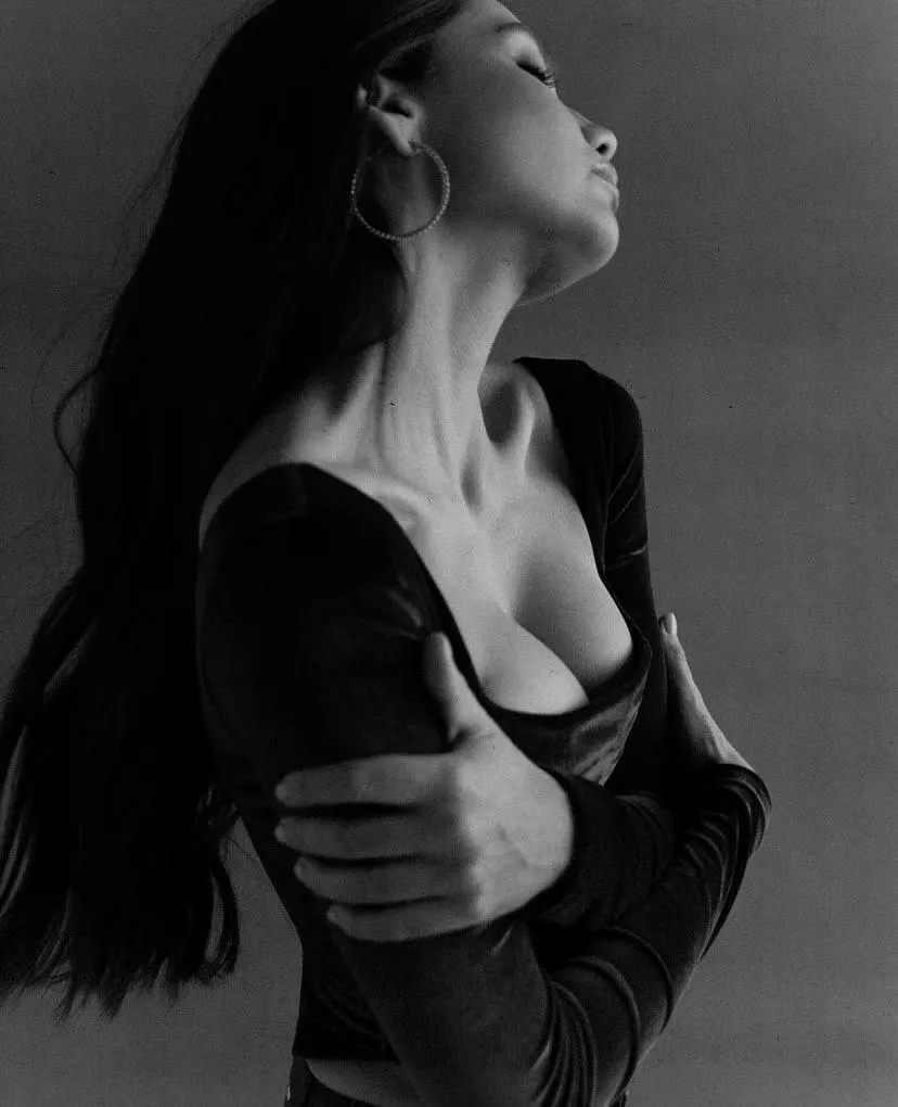 Black and white portrait of a woman holding her chest softly