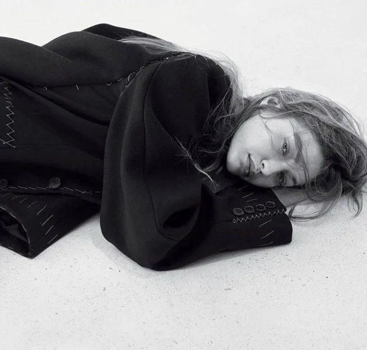 Black and white portrait of a woman resting in a cozy jacket