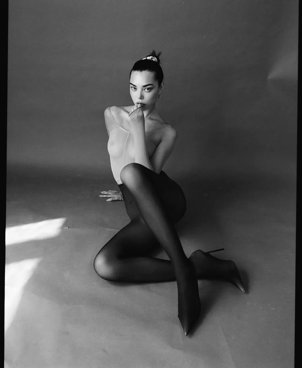 Black And White Portrait of a Woman Sitting with Legs Crossed
