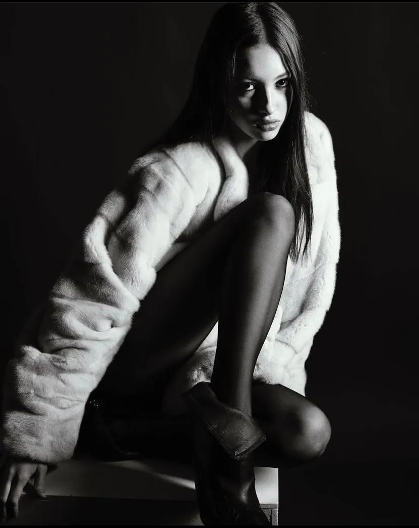 Black and white portrait of a woman wrapped in a fur coat