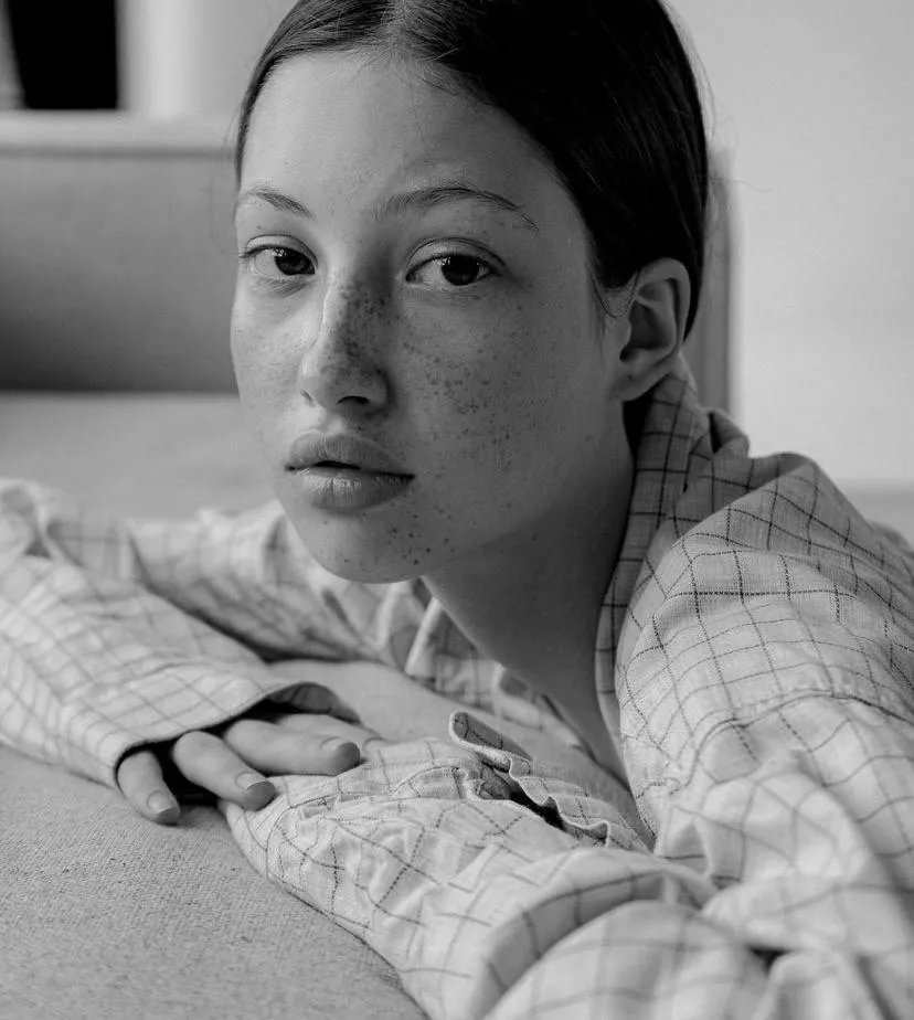 Black and white portrait of woman lying with soft expression