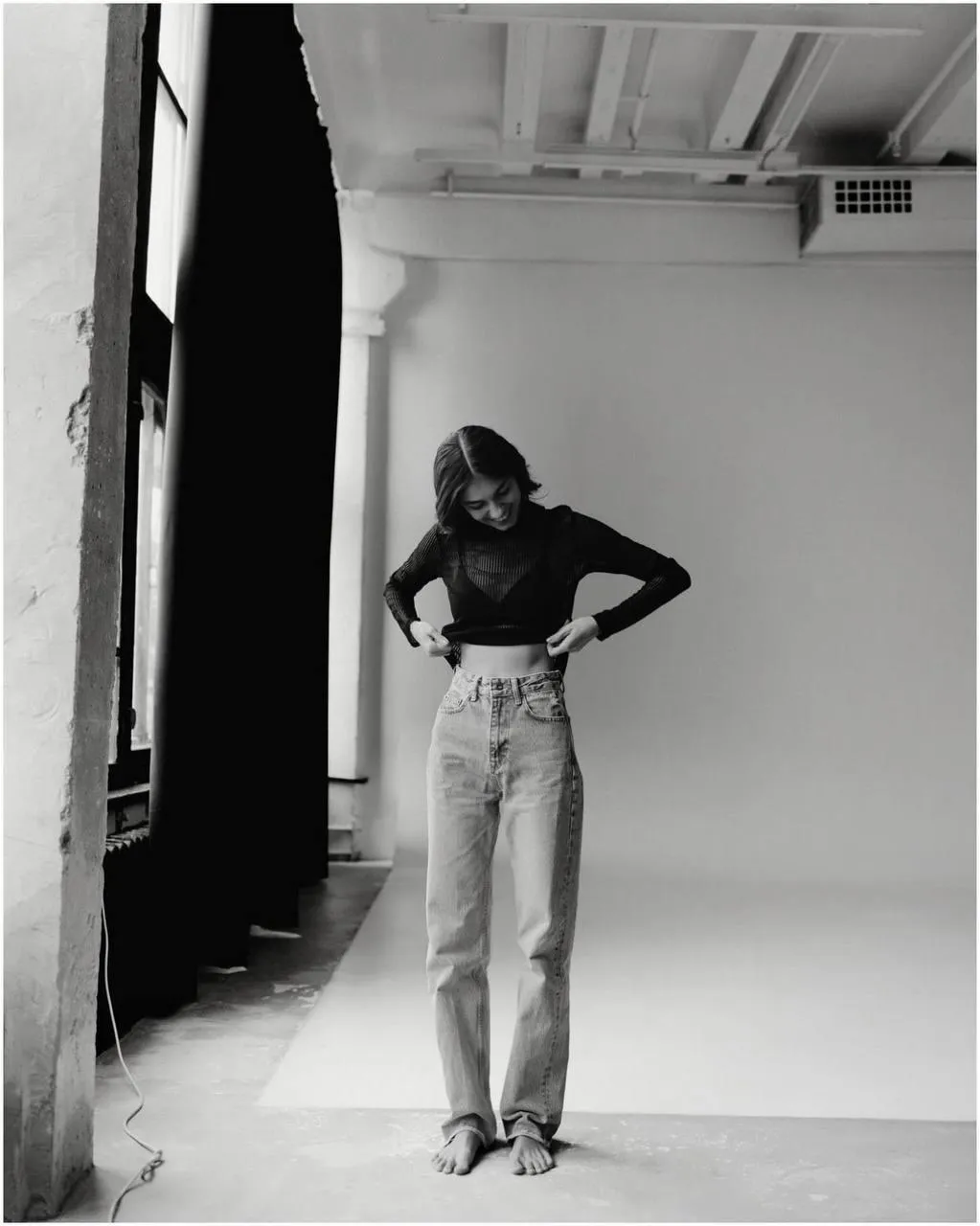 Black and white shot of a woman in jeans and a black top