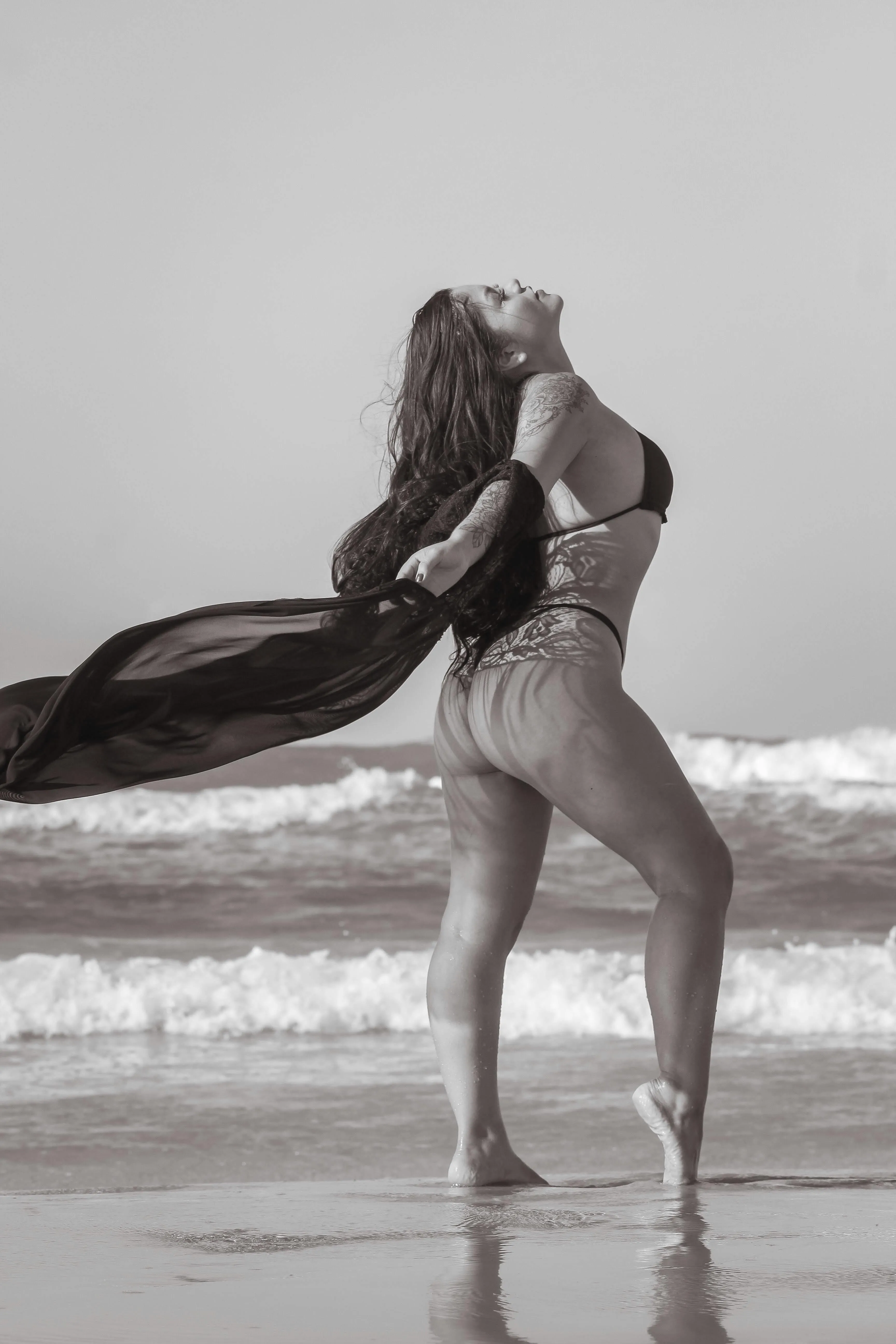 Black And White Shot of a Woman Posing on the Beach Sand