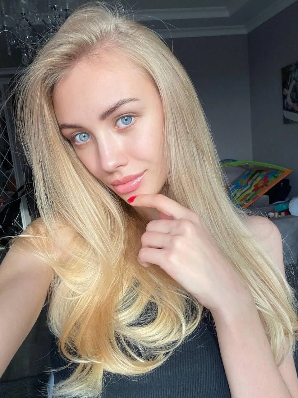 Blonde Girl with Soft Smile Posing Indoors Near the Bed