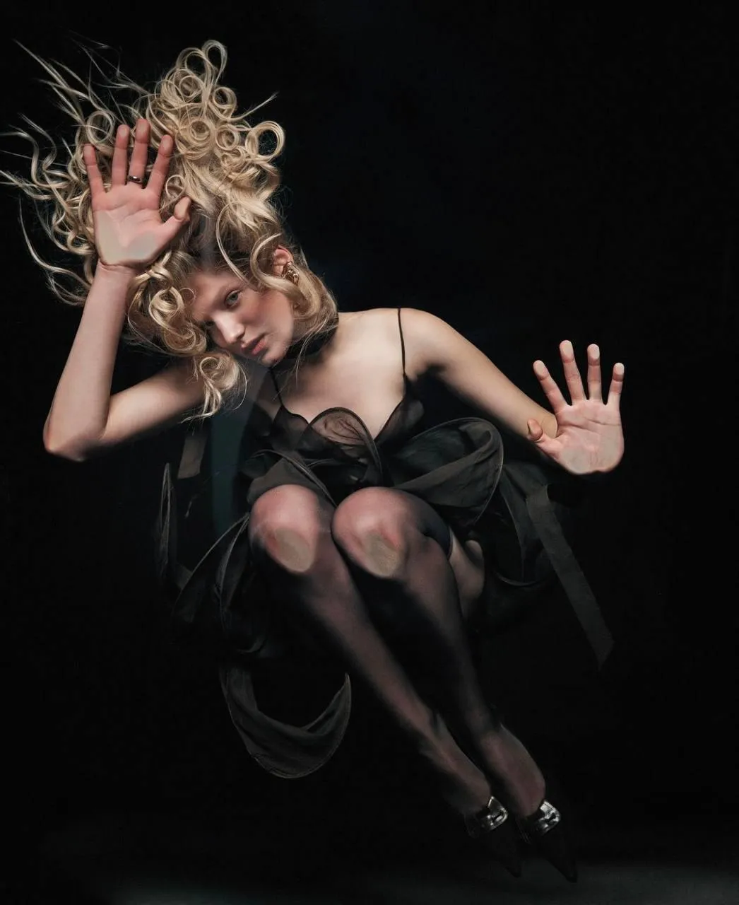 Blonde woman in a black dress mid motion with flair image