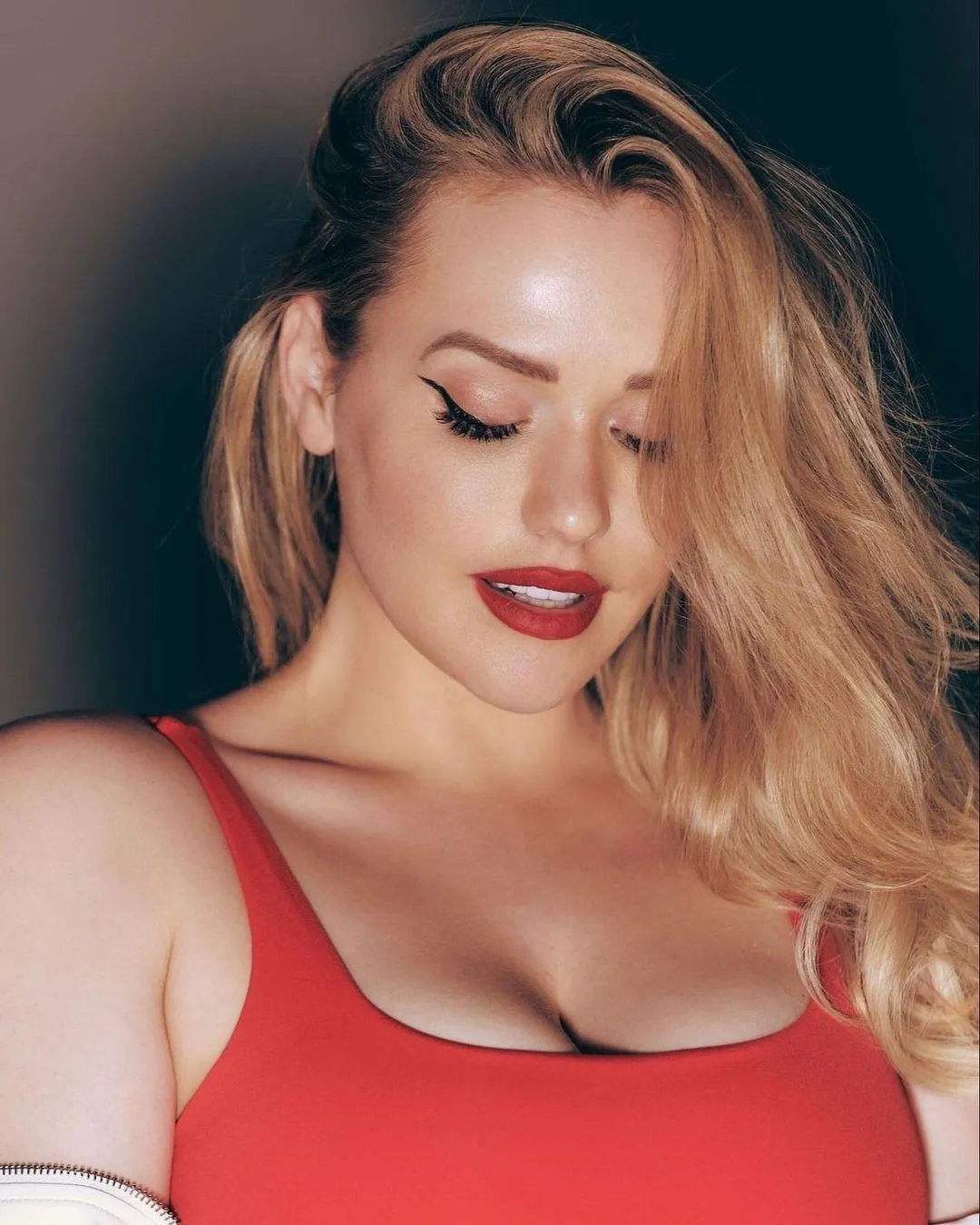Blonde Woman in a Red Top Looking Down with Studio Lighting