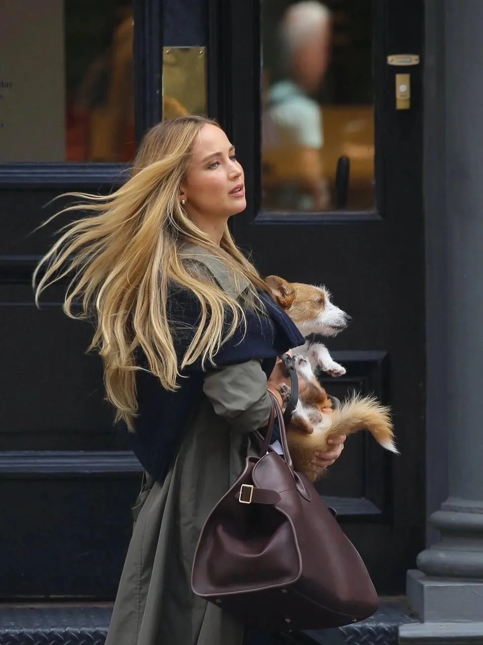 Blonde Woman Walking City Street Holding a Dog And a Handbag